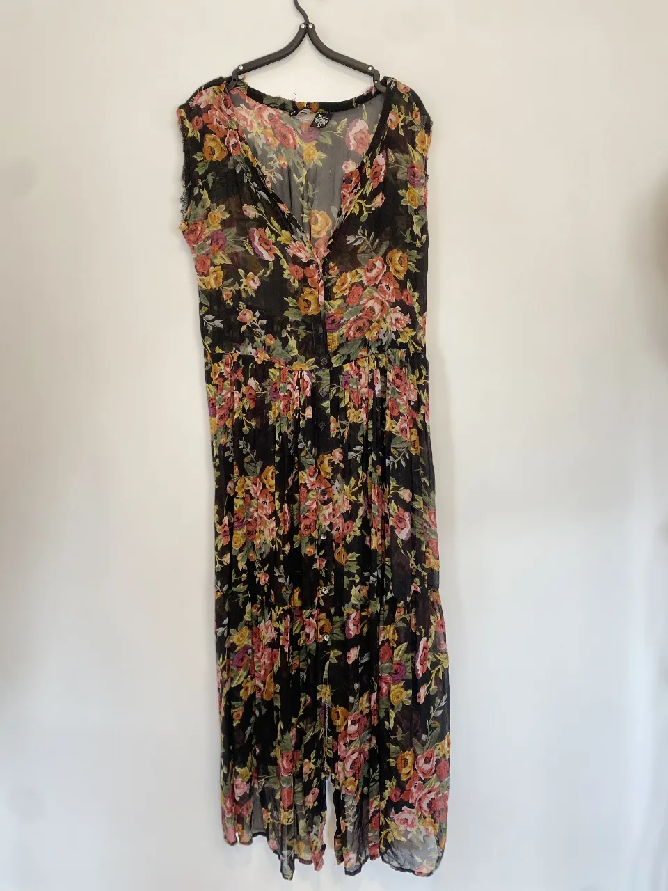 Vestido largo de gasa transparente con estampado floral en tonos amarillos, rosas y naranjas sobre fondo negro. Corte holgado, con botones en el frente y mangas cortas. Ideal para un look bohemio y fresco. Tiene esos desgastes que se ven en las fotos por eso el precio.
Hombros 40 axilas 49 línea de cintura 44 largo 129