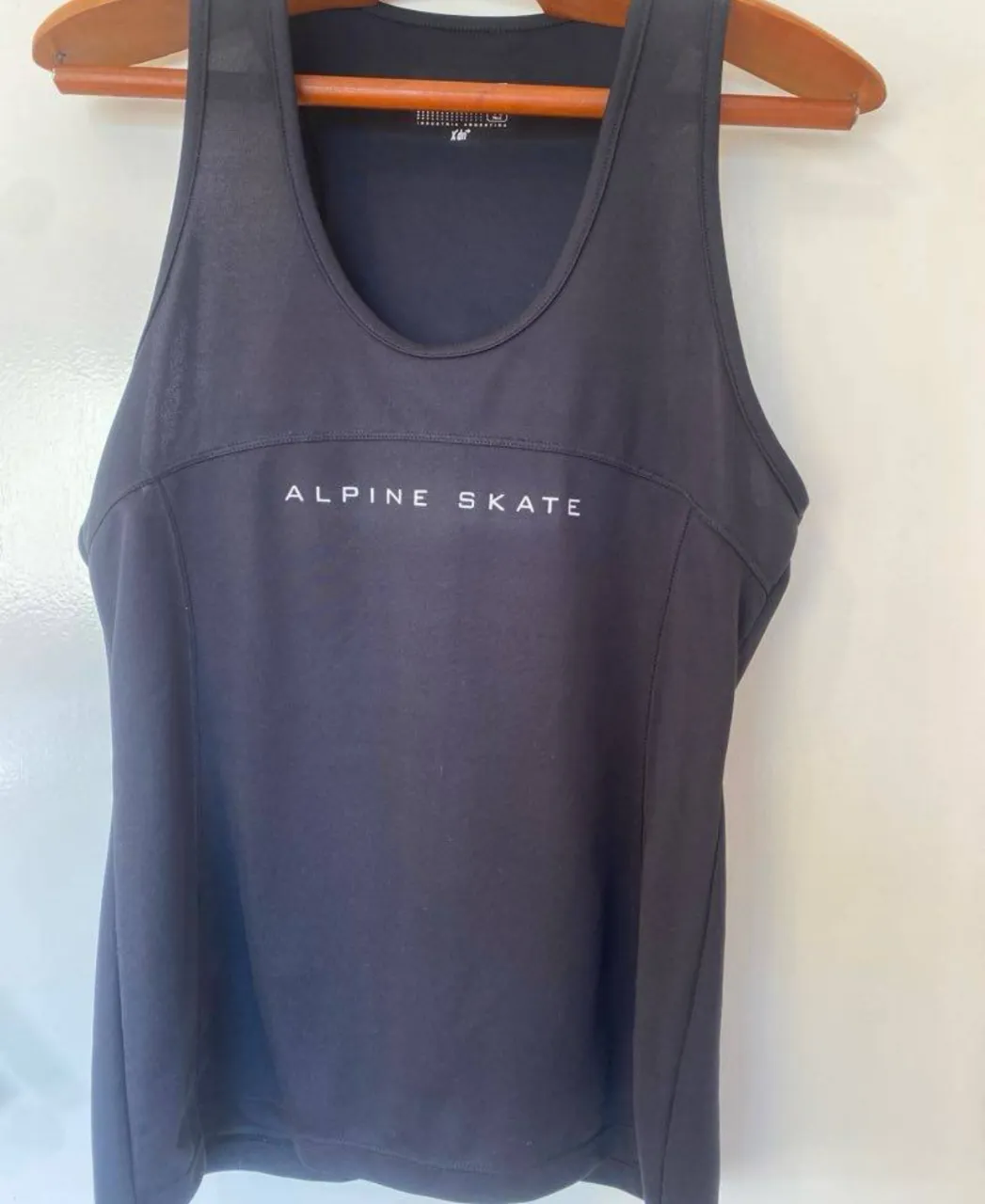 Musculosa deportiva negra con la inscripción "ALPINE SKATE" en blanco. Ideal para actividades físicas.
