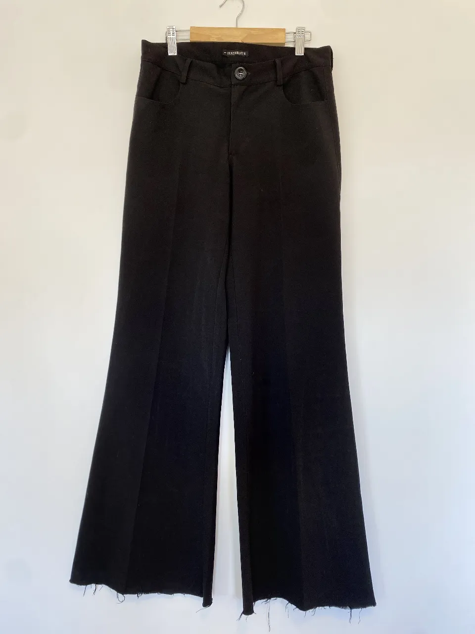 Pantalón sastrero negro de mujer, con corte campana y detalle de flecos en el borde. Tiro alto y calce perfecto para un look elegante y moderno. Dice talle 1 pero ver medidas
Cintura 40, tiro 24, largo 105, Botamanga 32