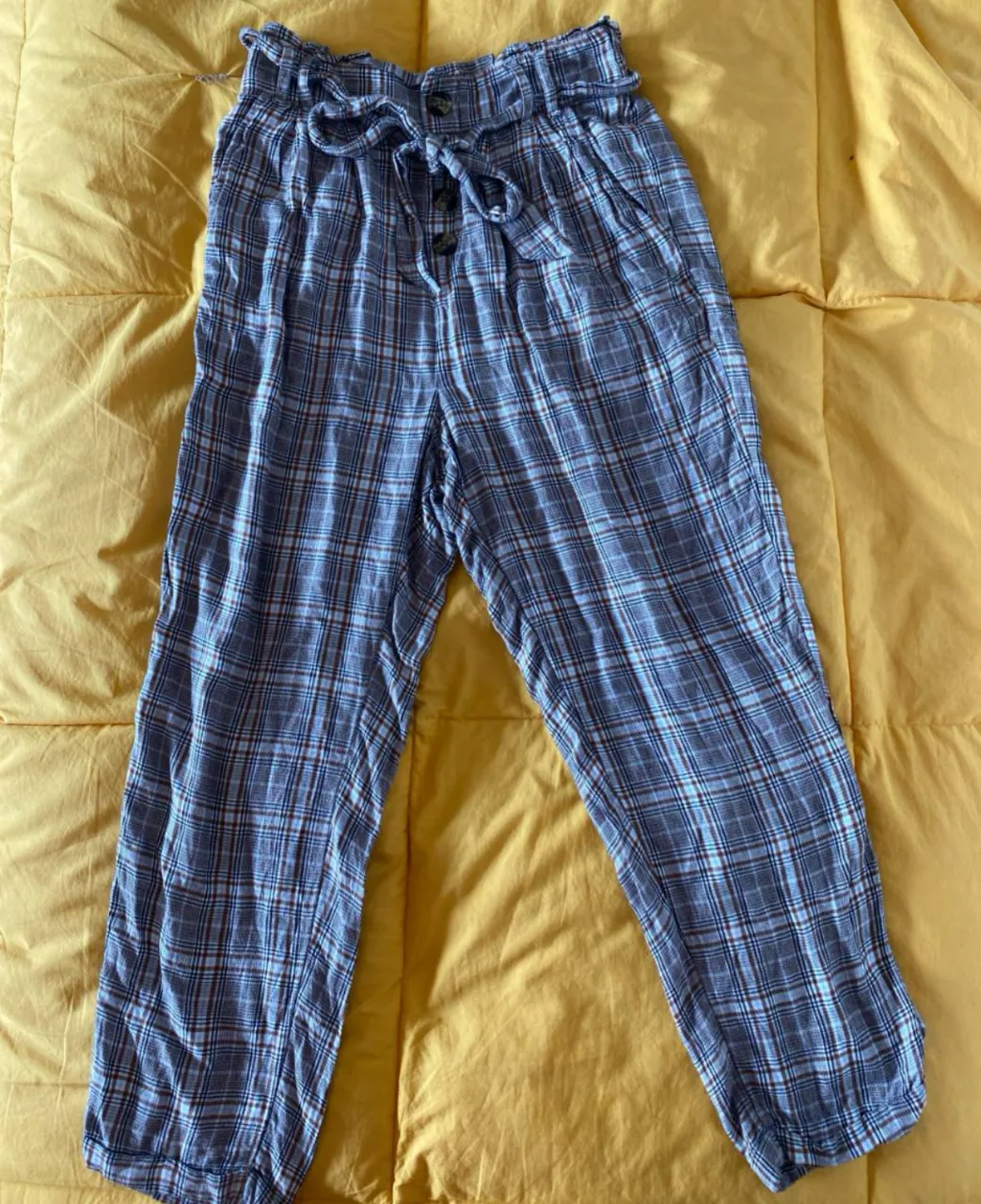 Pantalón suelto de mujer, con estampado a cuadros en tonos azules y marrones. Cintura alta con detalle de lazo y botones. Ideal para un look casual y cómodo. cintura mínimo 32 máximo 37, cadera aprox 52, largo 87