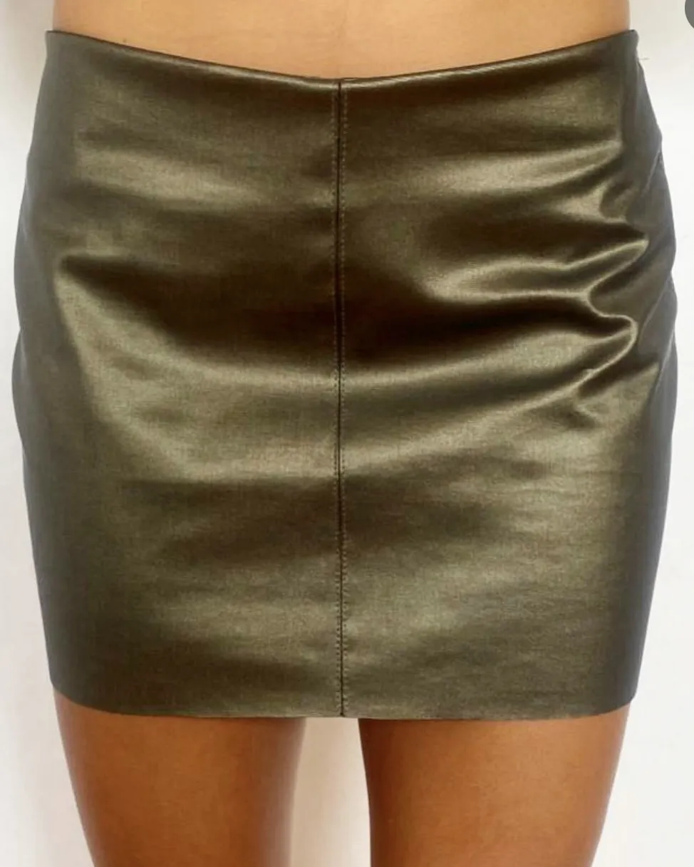 Minifalda de cuero sintético color verde oscuro, con cierre en la parte trasera. Ideal para un look de fiesta o salida.cintura 35 cadera 45 largo 31tiene un poquito descosido cerca del cierre