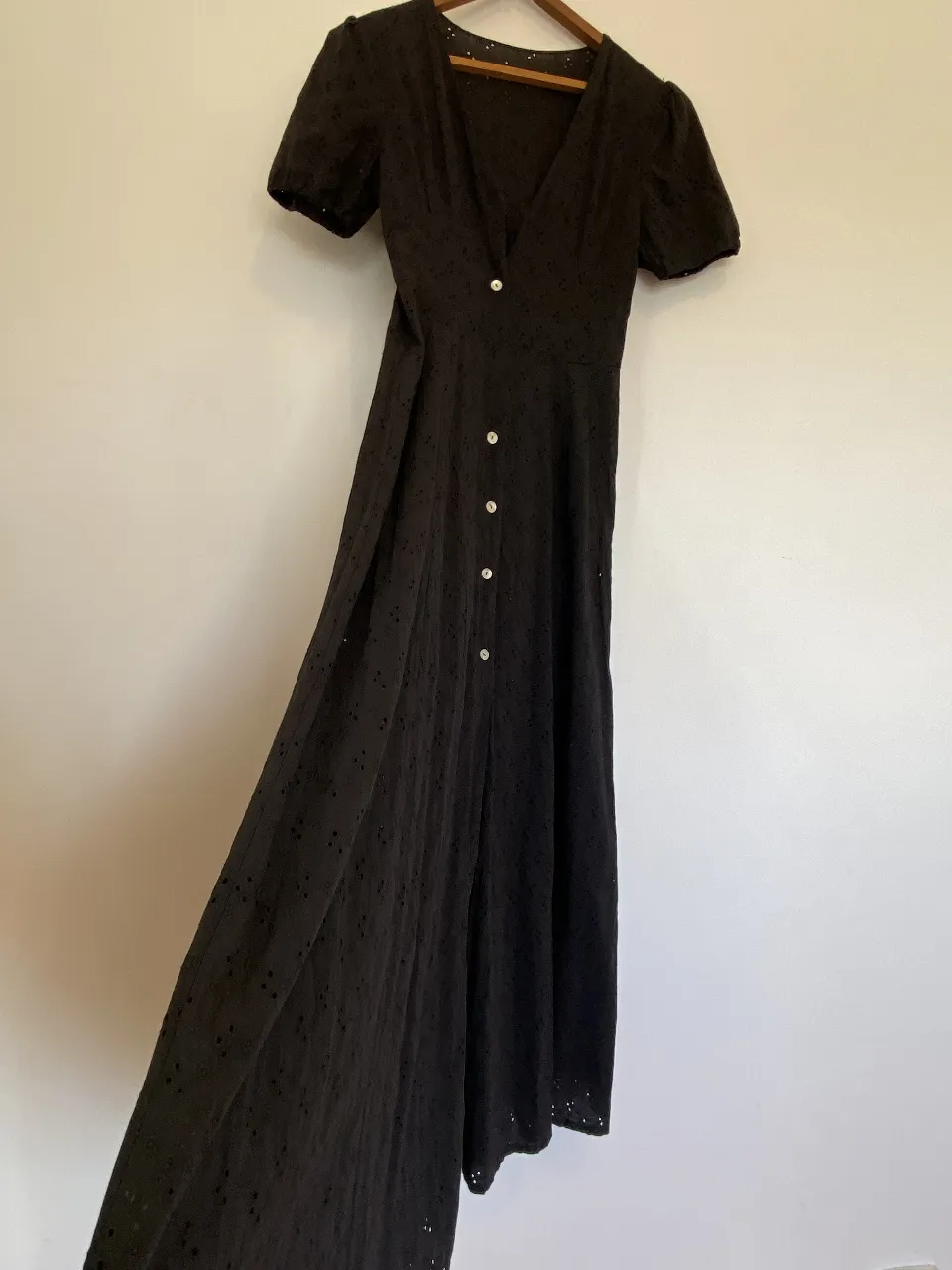 Vestido camisero largo y negro con detalles calados y botones frontales. mangas cortas con Frunce.  Ideal para un look elegante y fresco. le falta el primer y tercer botón 
Hombros 40, axilas 43, cintura 36, Largo, 138