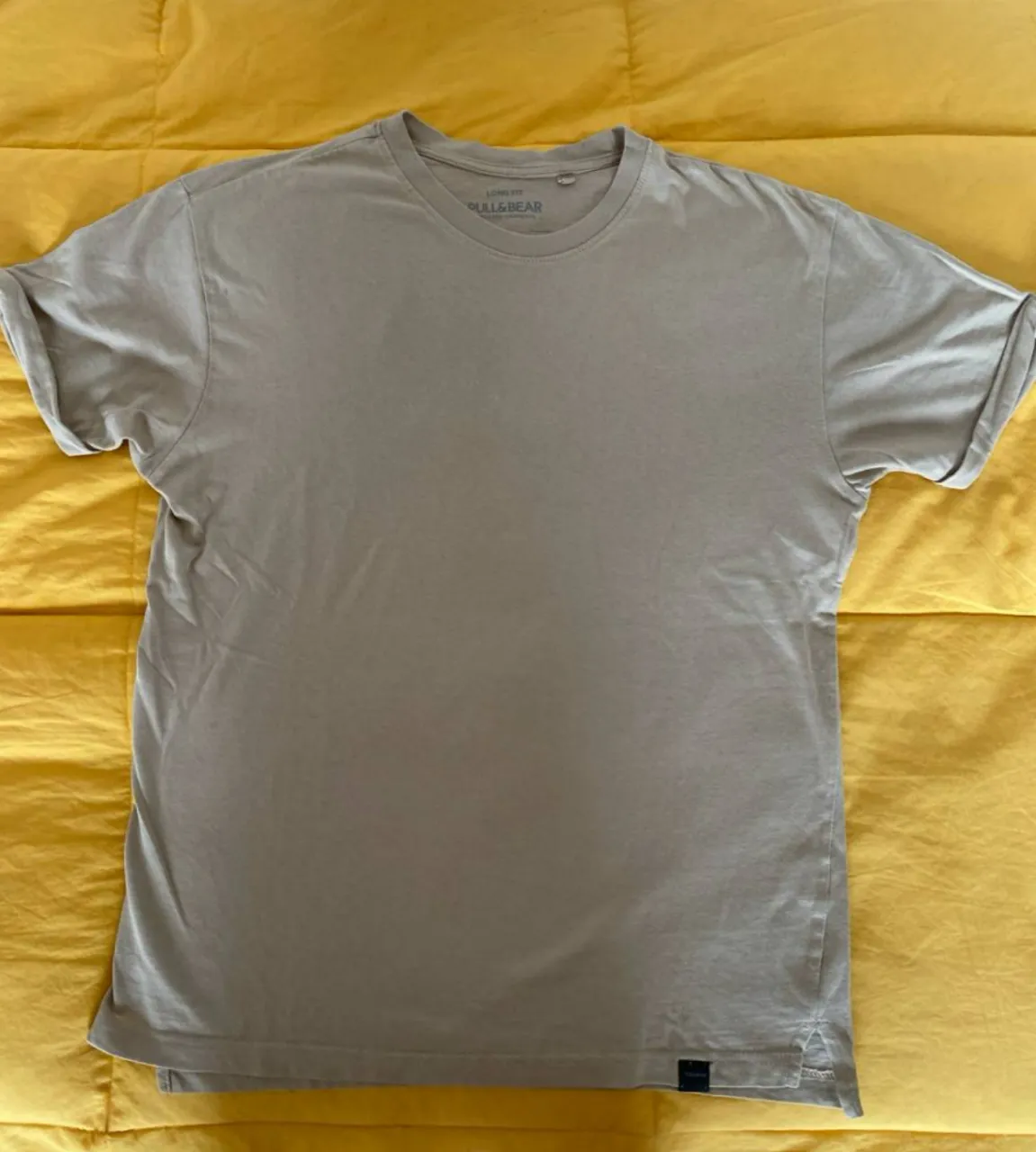 Remera manga corta de hombre, color crudo, de la marca Pull&Bear. Corte recto y cuello redondo. Ideal para un look casual y cómodo.