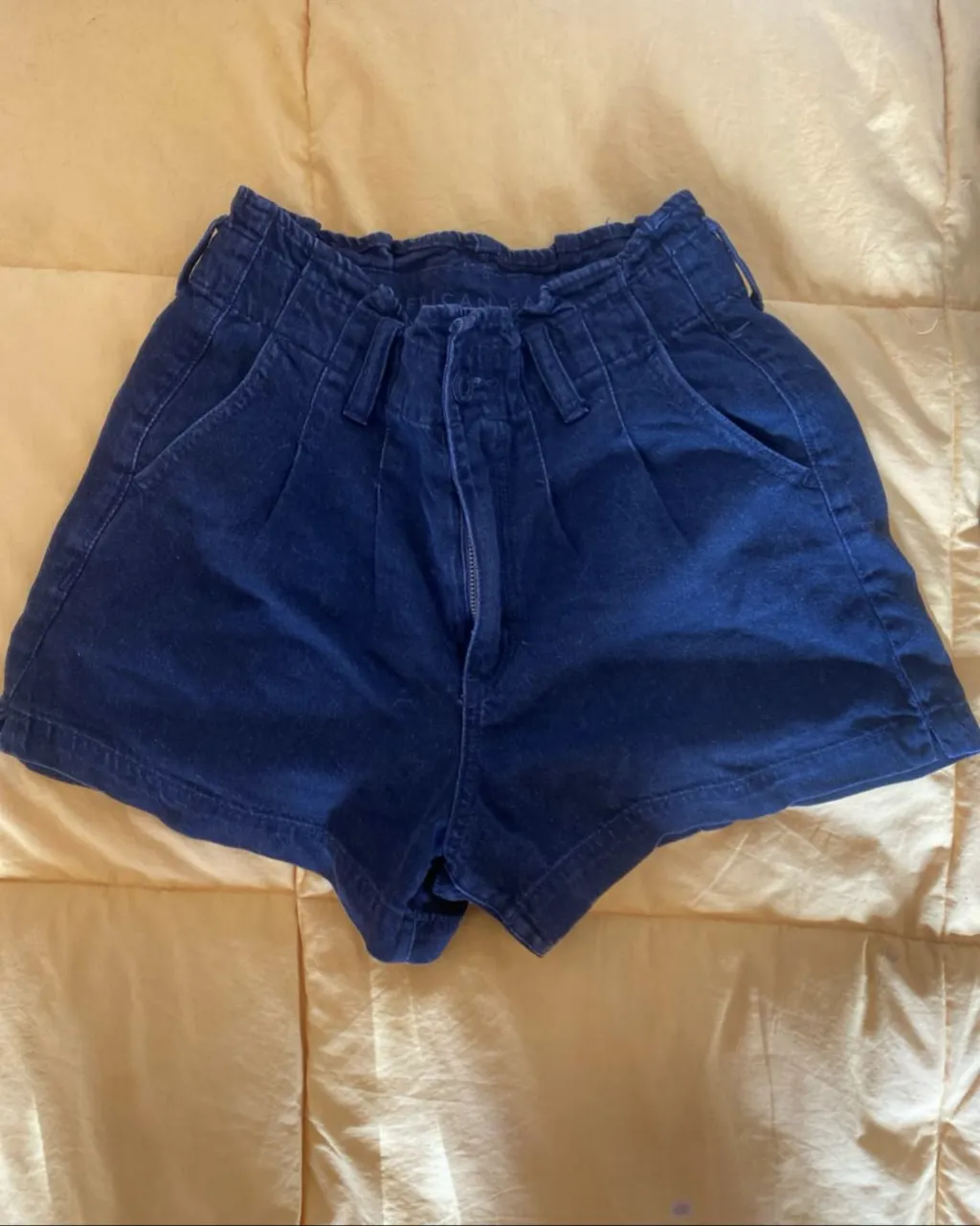 Short de jean de mujer, tiro alto, con pinzas y bolsillos. Marca American Eagle, talle 0 US. cintura 31, cadera 47, largo 33