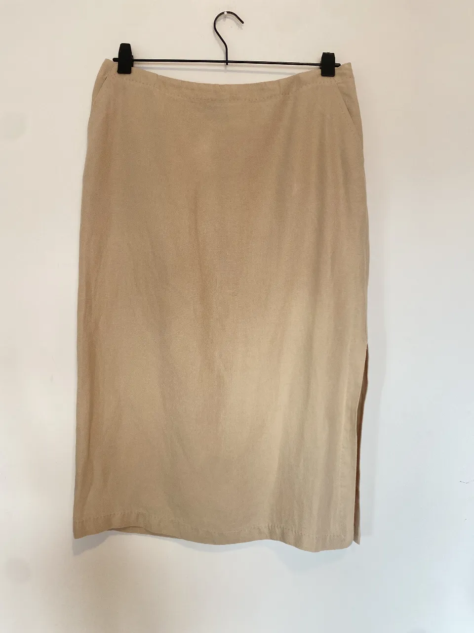 Pollera sastrera de lino color crudo, con tajo lateral y bolsillos. Ideal para un look elegante y fresco. Cintura 41, largo 75
Tiene una manchita atrás, por eso el precio