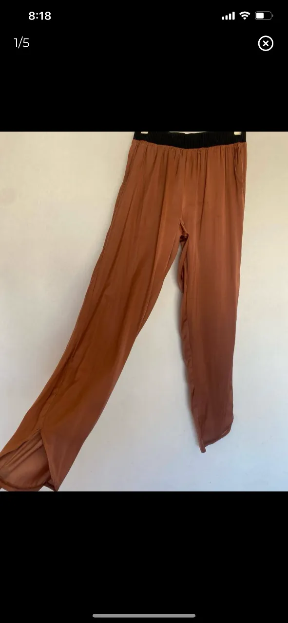 Pantalón suelto de mujer, color marrón, con cintura elastizada negra. Detalles de abertura en los bajos. Ideal para un look cómodo y con estilo. detalle : manchita que se ve en la foto x eso el precio 
cintura 33-44 
cadera a la altura del tiro 50
largo 95
