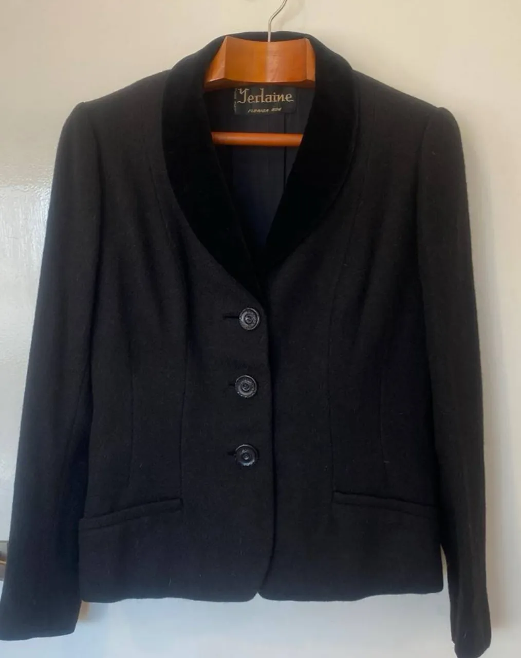 Elegante blazer negro de mujer, de paño con solapa de terciopelo y tres botones. Ideal para un look formal o de trabajo. detalle: un poco descosido el forro interno en la parte de atrás y las pelotitas o pelitos típicos que se pegan al paño 
