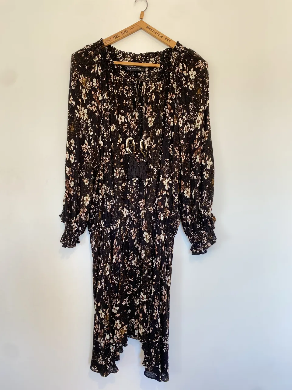 Vestido midi de mujer con estampado floral en tonos negro y blanco. Diseño con mangas largas y detalles fruncidos, ideal para un look bohemio y elegante.