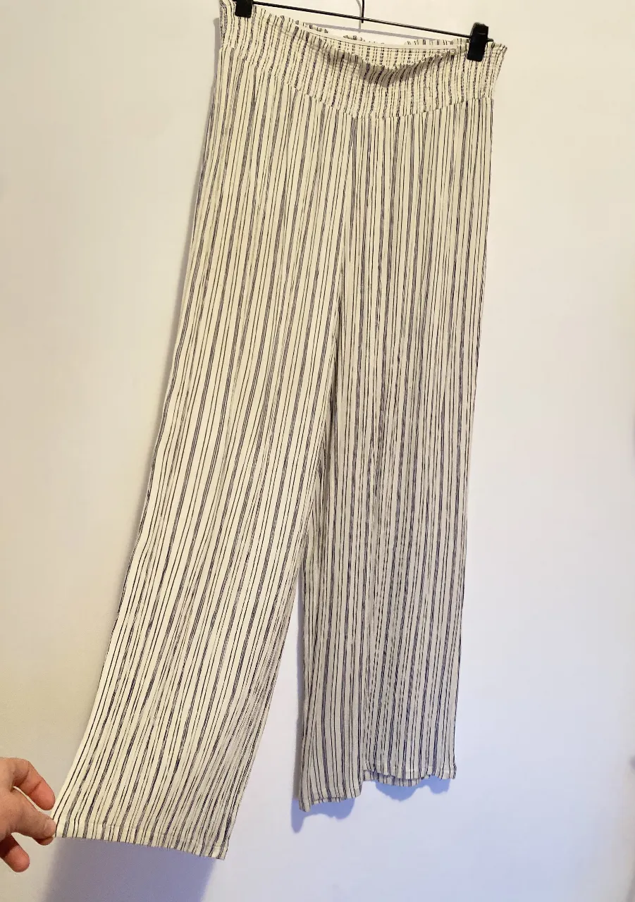 Pantalón de mujer, de tela liviana, con rayas verticales en blanco y azul. Tiene cintura elastizada y corte amplio, ideal para un look fresco y cómodo. 100% rayón. cintura 40-50, Largo 108