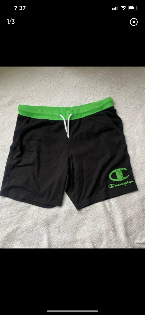 Short deportivo Champion negro con cintura verde y logo en verde. Ideal para actividades físicas o uso casual.