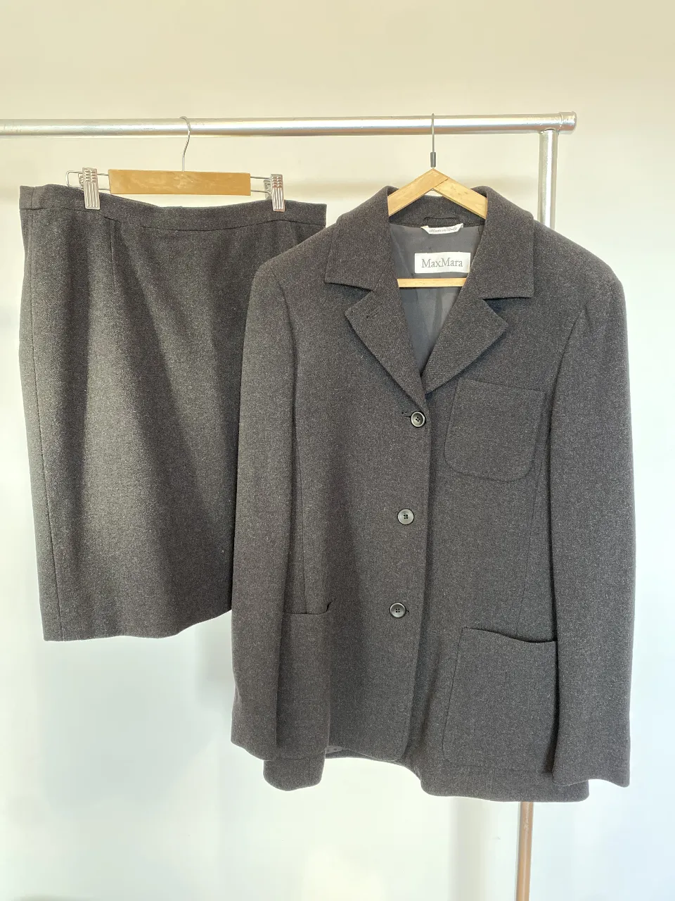 Conjunto de blazer y pollera MaxMara en color gris oscuro. Blazer con solapas, bolsillos y cierre con botones. Pollera a la rodilla. talle 44. impecable! 