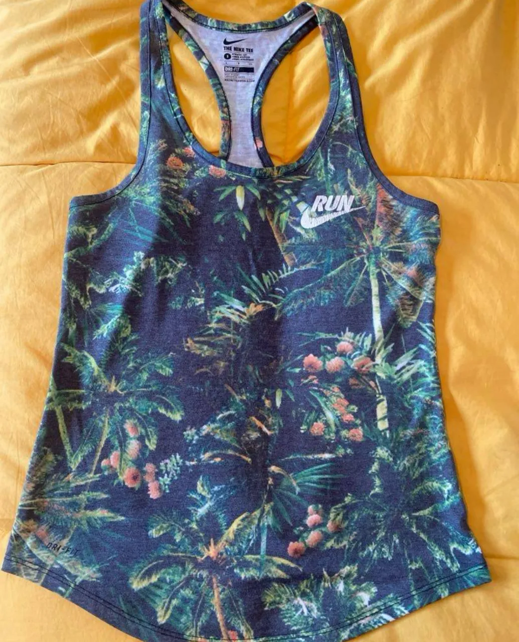 Musculosa deportiva Nike para mujer, con estampado tropical. Ideal para running y entrenamientos. Talle S.