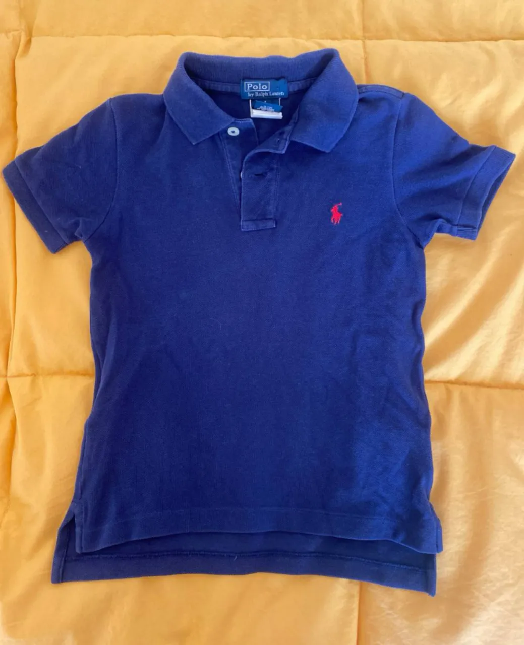 Remera polo azul marino de niño, con el logo de Ralph Lauren bordado en rojo. Ideal para un look casual y cómodo.