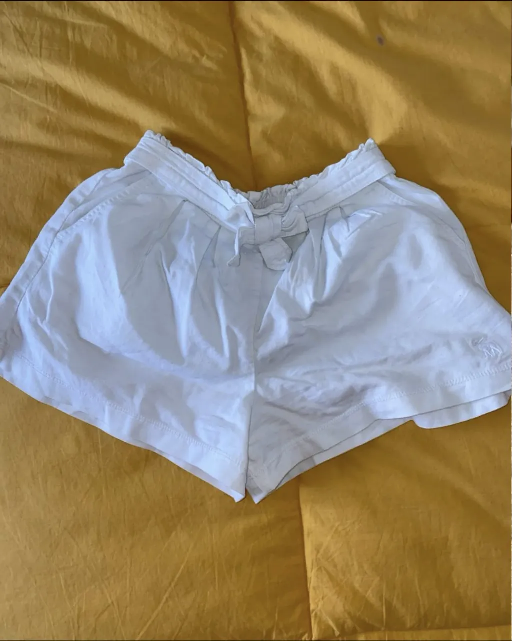 Shorts blancos de tela con cintura elastizada y moño. Talle 11/12 de Abercrombie & Fitch. Ideal para un look casual y fresco. Cintura sin estirar 29, largo 28