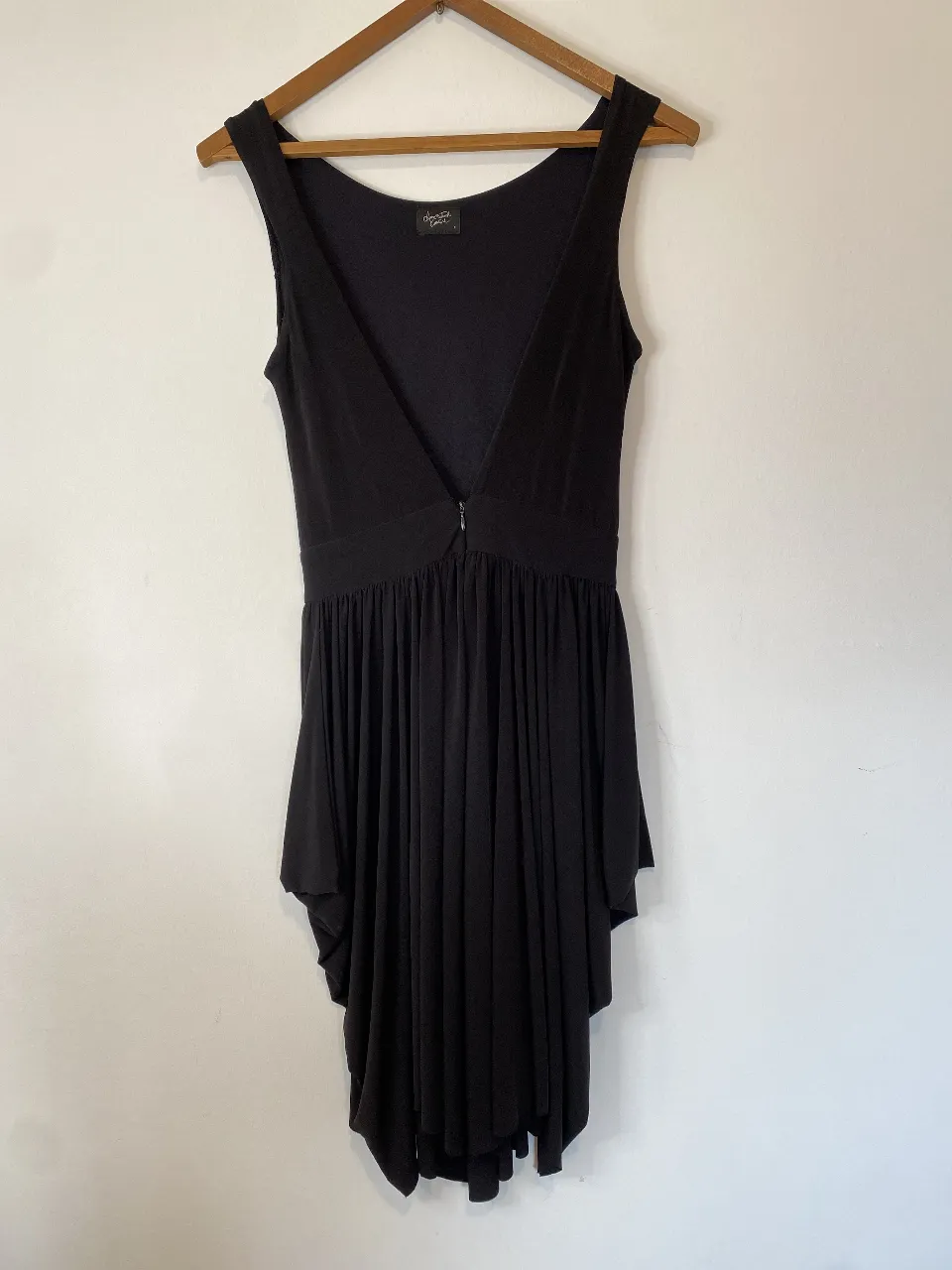Vestido midi negro con diseño asimétrico y detalle drapeado. Ideal para eventos especiales o salidas nocturnas. Confeccionado en tela suave y fluida. Sólo tienes ese pequeño descosido que se ve en la foto con zoom