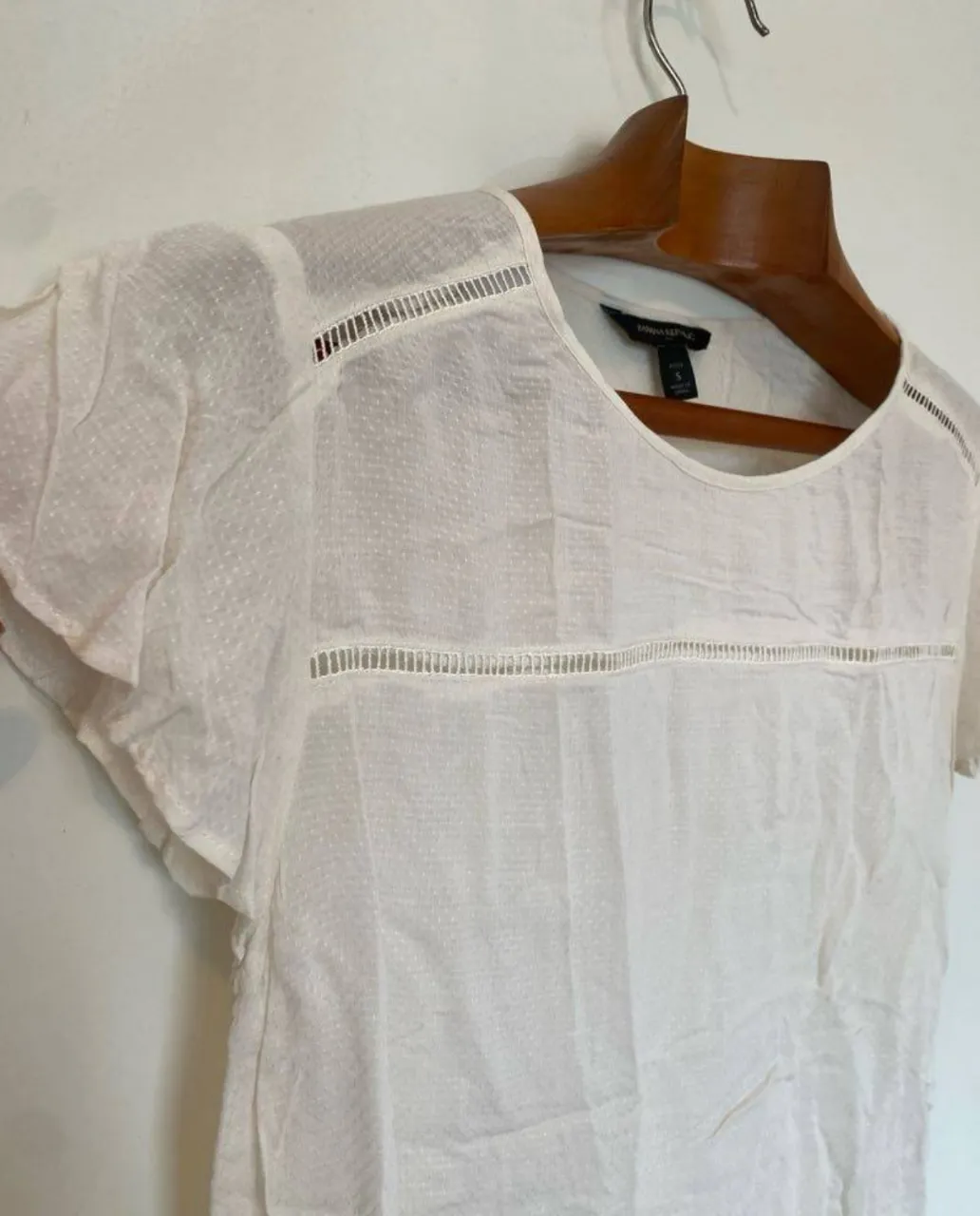 Blusa blanca de mujer, con detalles calados y mangas cortas. Ideal para un look fresco y casual.
