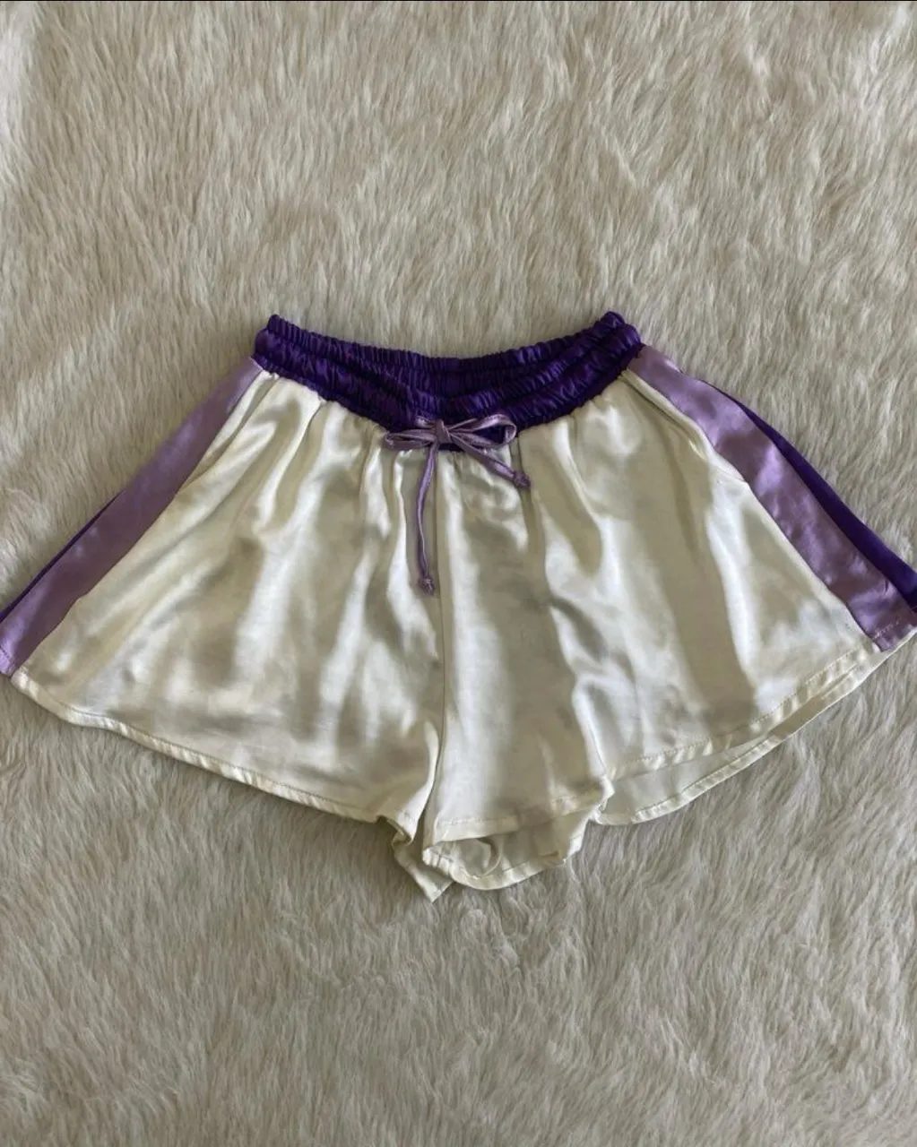 Short deportivo de mujer, blanco con cintura y detalles en violeta. Ideal para actividades físicas o para un look casual y cómodo. 