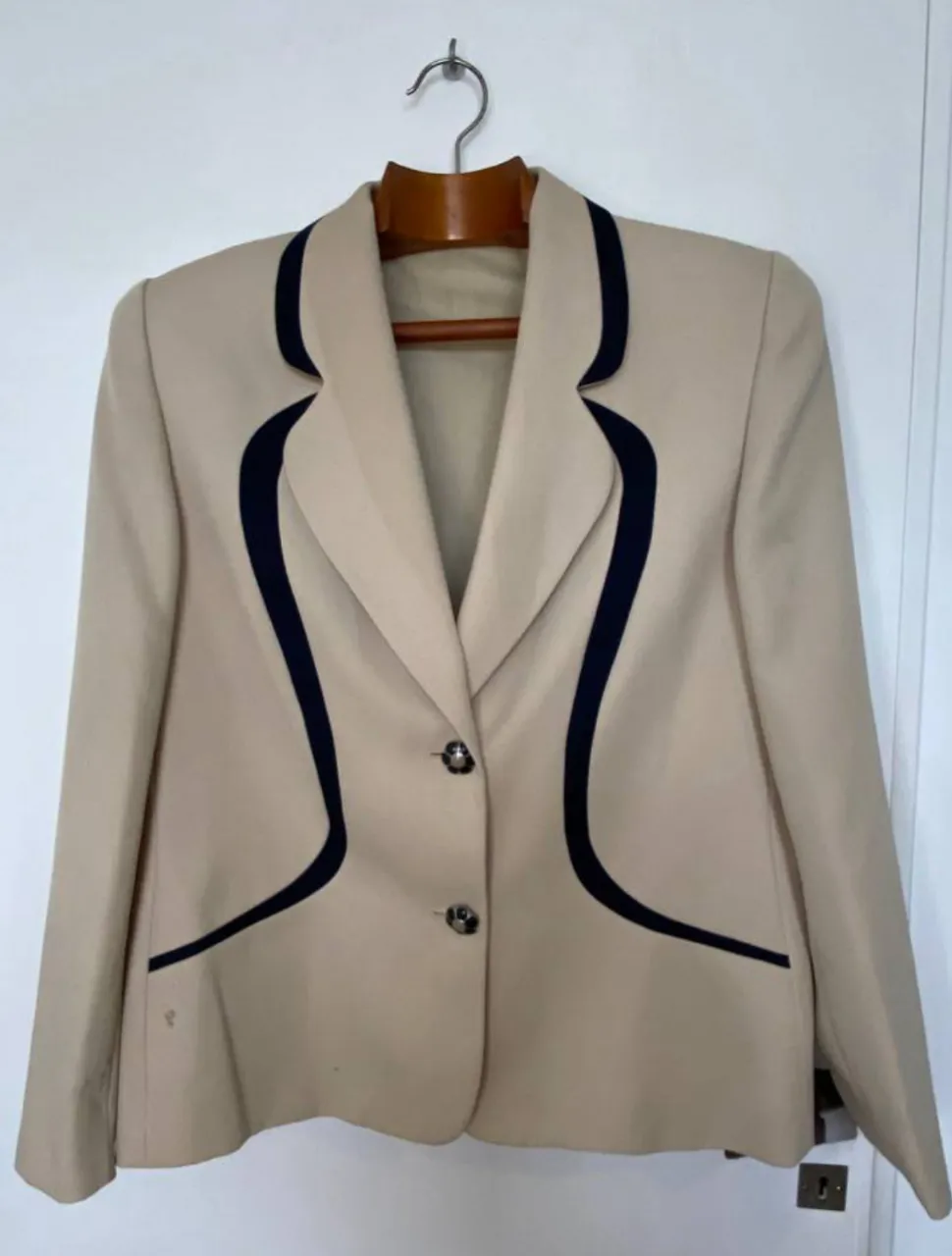 Blazer beige con detalles en negro. Corte clásico, ideal para un look elegante y sofisticado. Perfecto para combinar con pantalones sastreros o jeans. en la foto se ve los detalles que tiene
hombros 42 
axilas 48 
mangas 64 
largo 66
