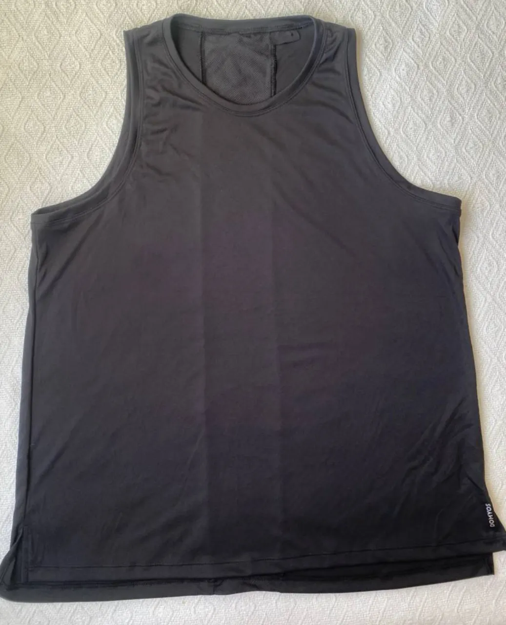 Musculosa deportiva negra para hombre, ideal para entrenamientos. Diseño con espalda en mesh para mayor ventilación y logo de la marca en la parte inferior.