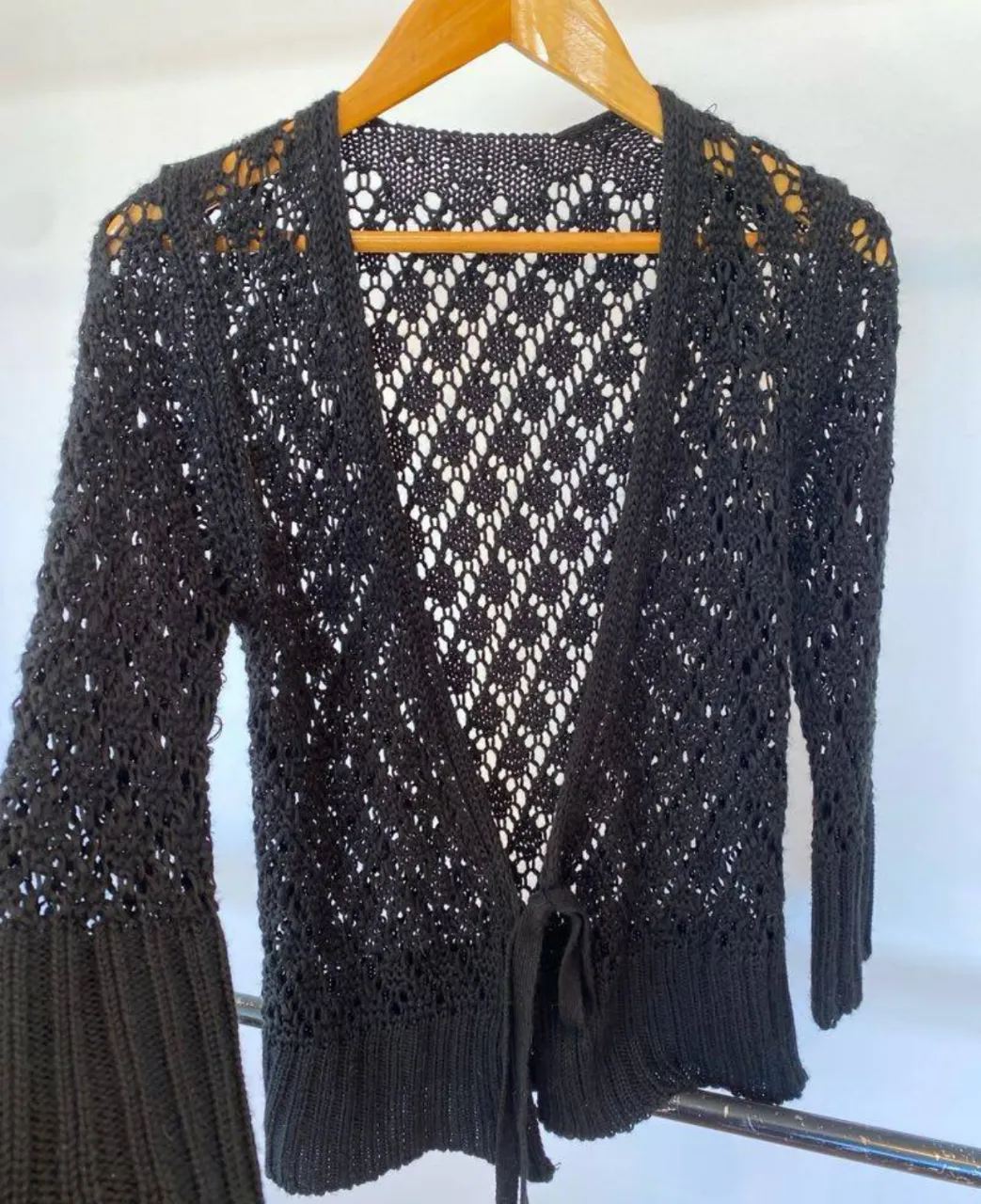 Cardigan negro calado con lazo en la cintura. Ideal para un look casual y elegante. Único detalle es en la última foto que está un poco suelto el punto