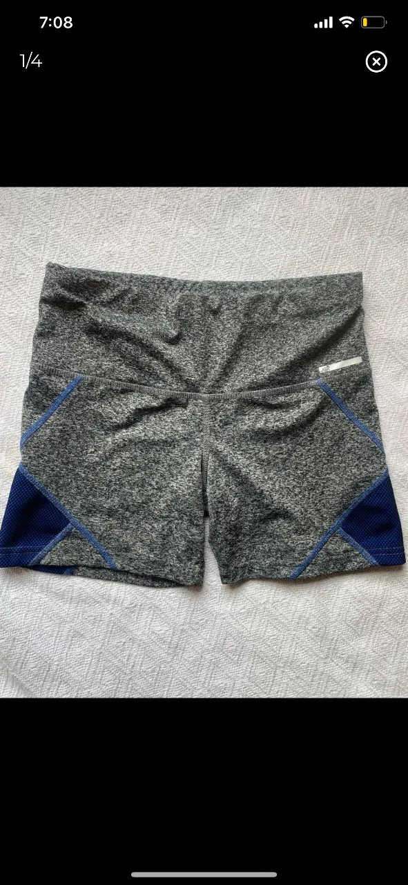 Biker deportivo, color gris con detalles en azul. Ideal para actividades físicas.