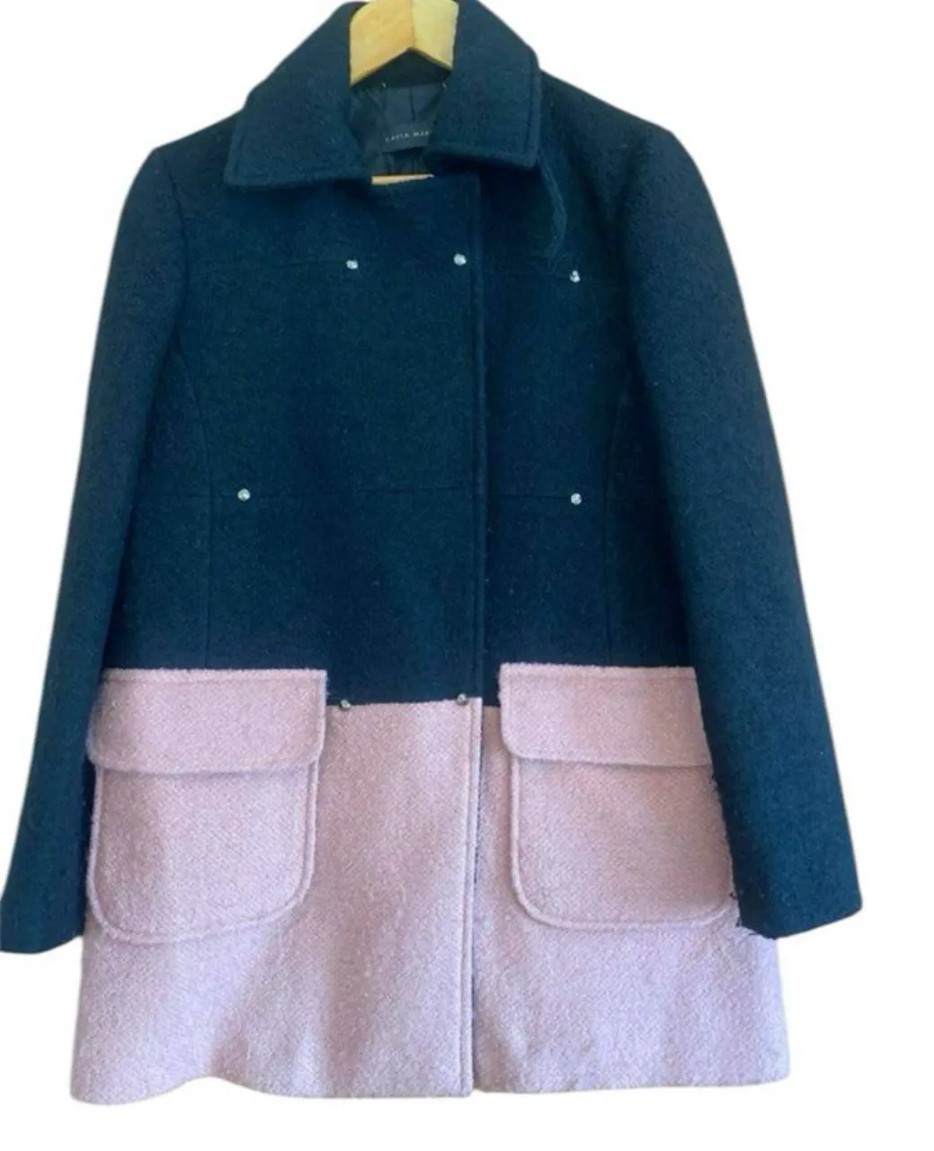 Tapado de paño para mujer, con diseño bicolor en negro y rosa. Posee dos bolsillos delanteros y botones. Ideal para el invierno. 80% lana