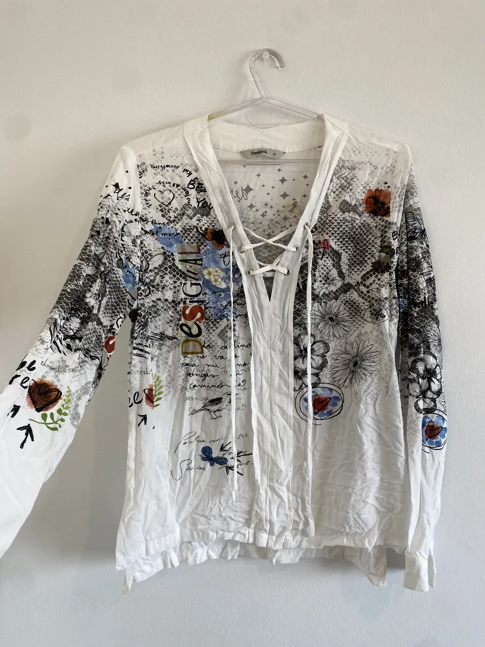Blusa blanca con estampado artístico y diseño con motivos de graffiti, flores y animales. Ideal para un look casual y con estilo.
Axilas 50, largo delantero 60, largo trasero 70
la tela es súper suave. divina!