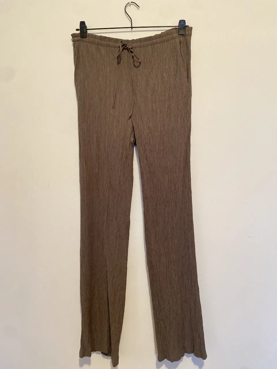 Pantalón suelto de mujer, color marrón, con cintura elastizada, cordón y bolsillos de Zara. Ideal para un look casual y cómodo. Viscosa y poliamida.
Cintura mínimo 40, largo 107 