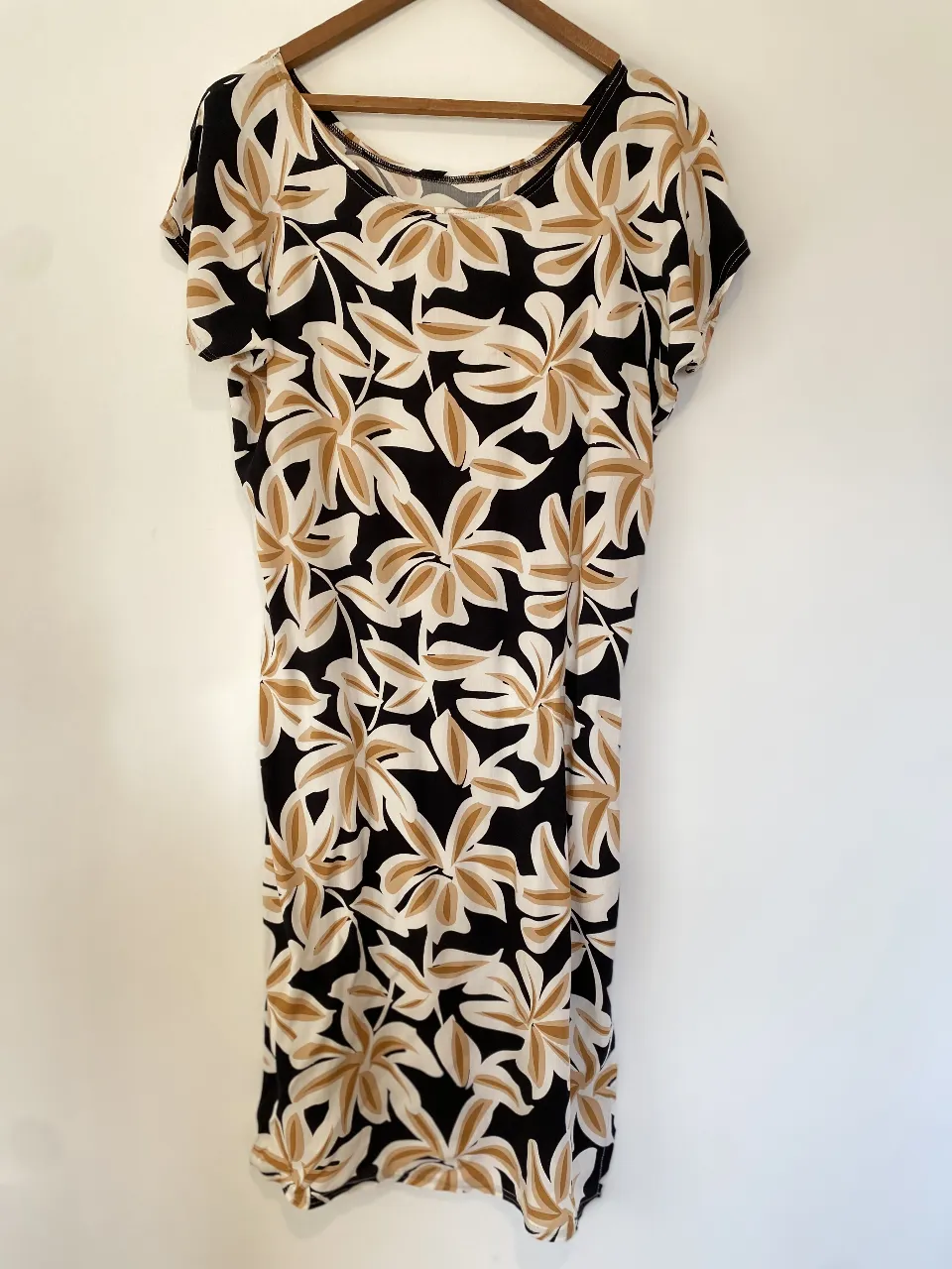 Vestido midi de mujer con estampado floral en blanco y marrón sobre fondo negro. Ideal para un look casual y fresco.