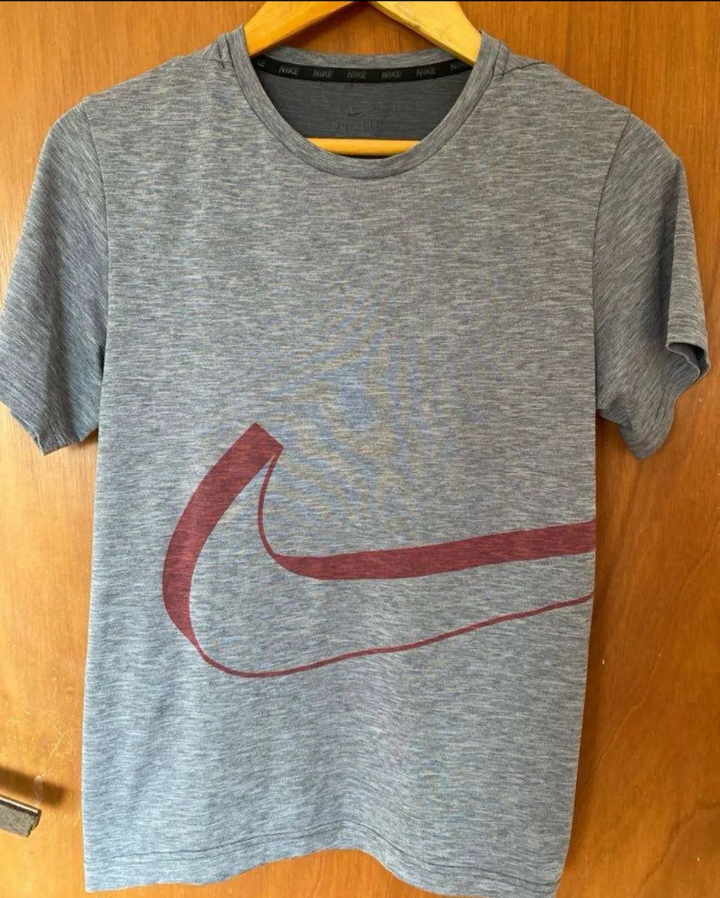 Remera deportiva Nike Dri-Fit gris con el logo en rojo. Talle XL. Ideal para entrenar.