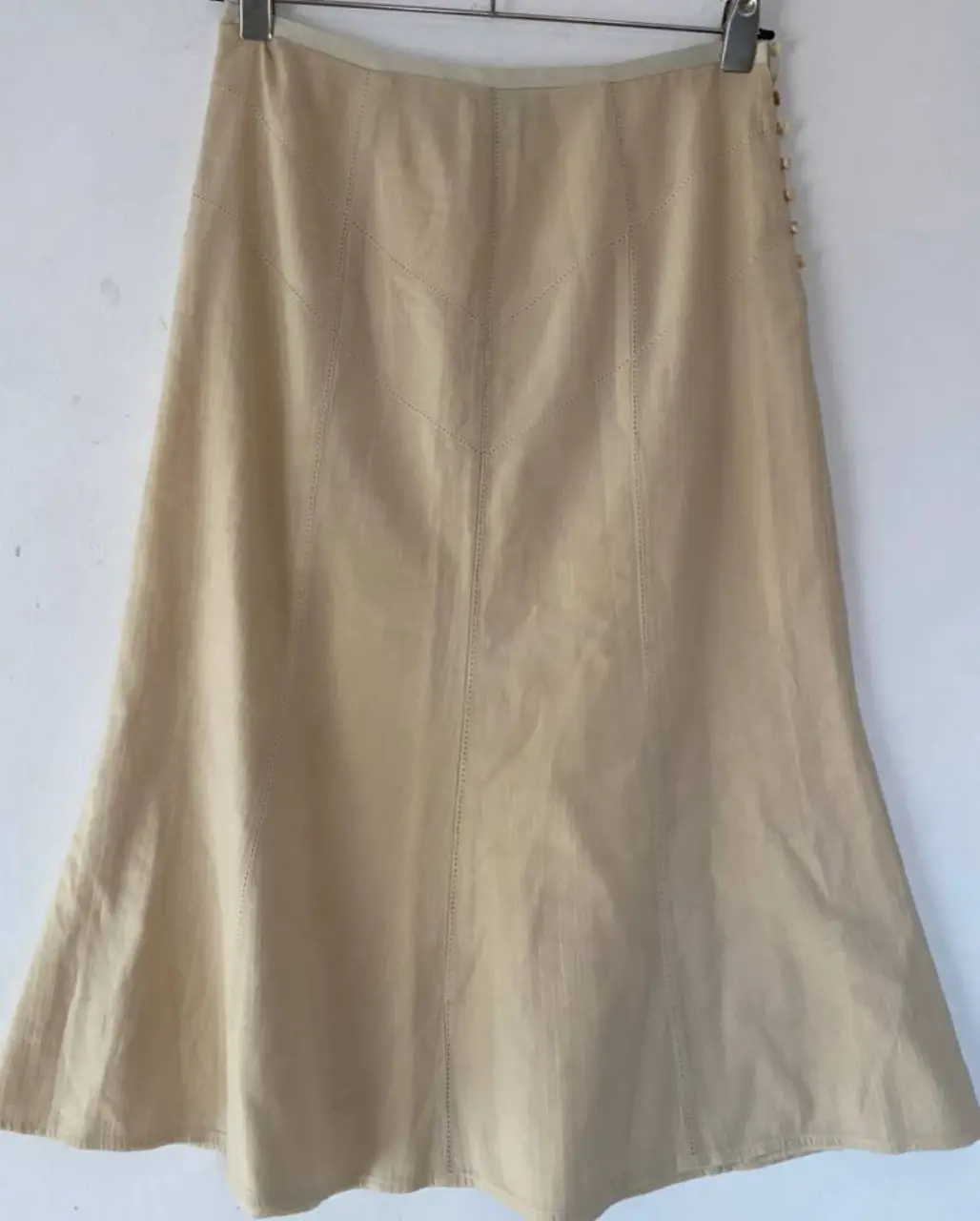 Pollera midi de color crudo con detalles de costura y botones en el lateral. Ideal para un look casual y elegante.tiene detalles preciosos de costuras acanaladas y abotonadura lateral (hay 1 boton diferente )cintura 37 largo 72