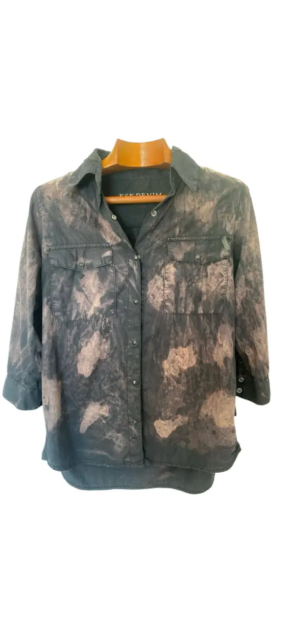 Camisa de mujer KSK DENIM con estampado tie dye en tonos negro y crudo. Manga 3/4 con botones en los puños y dos bolsillos delanteros. Ideal para un look casual y moderno.hombros 38 axilas 52 mangas 47 largo 72