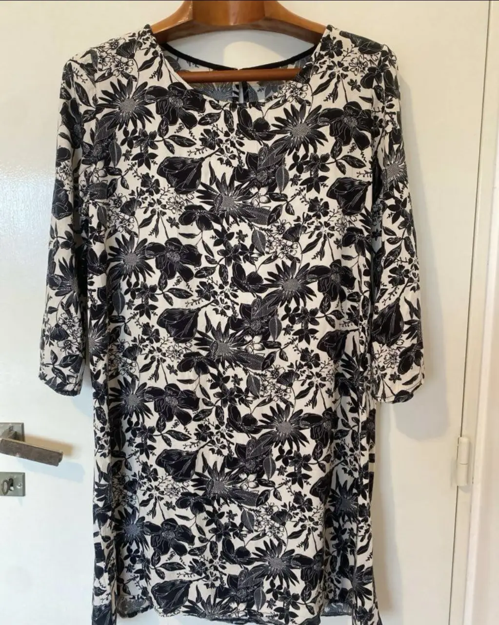 Vestido midi de mujer con estampado floral en blanco y negro. Corte recto, manga 3/4 y cuello redondo. Ideal para un look casual y cómodo.