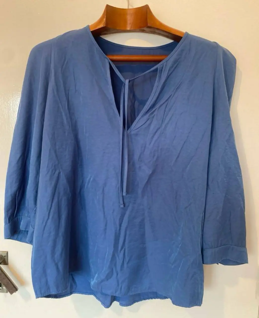 Blusa azul con escote en V con lazo y mangas 3/4. Ideal para un look casual y fresco.