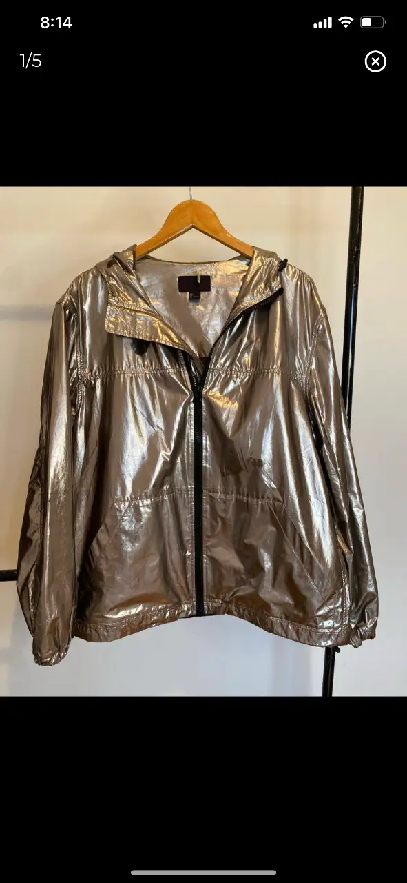 Campera metalizada en plata oscura con capucha. Ideal para un look moderno y canchero. Perfecta para días de lluvia o para darle un toque especial a tu outfit. tiene las marcas que se muestran en las fotos. hombros 54, axilas 67, mangas 65, largo 72