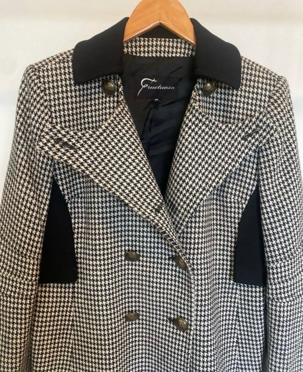 Tapado largo de mujer con estampado de pata de gallo en blanco y negro. Posee cuello solapa negro, botones dorados y detalles en negro en los laterales. Ideal para un look elegante y sofisticado. Talle 38 amplio (ver medidas) . hombros 41, axila 51, brazos 59, largo, 92