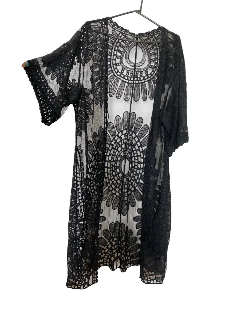 Kimono de encaje negro, ideal para usar sobre un vestido o como salida de playa. Diseño calado con detalles florales.