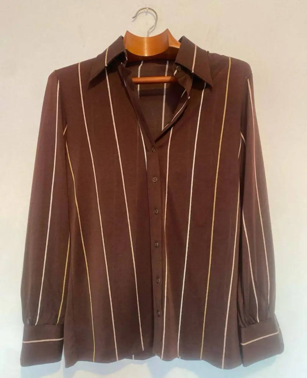 Camisa de mujer vintage con rayas verticales en tonos marrón y blanco. Ideal para un look retro y elegante.