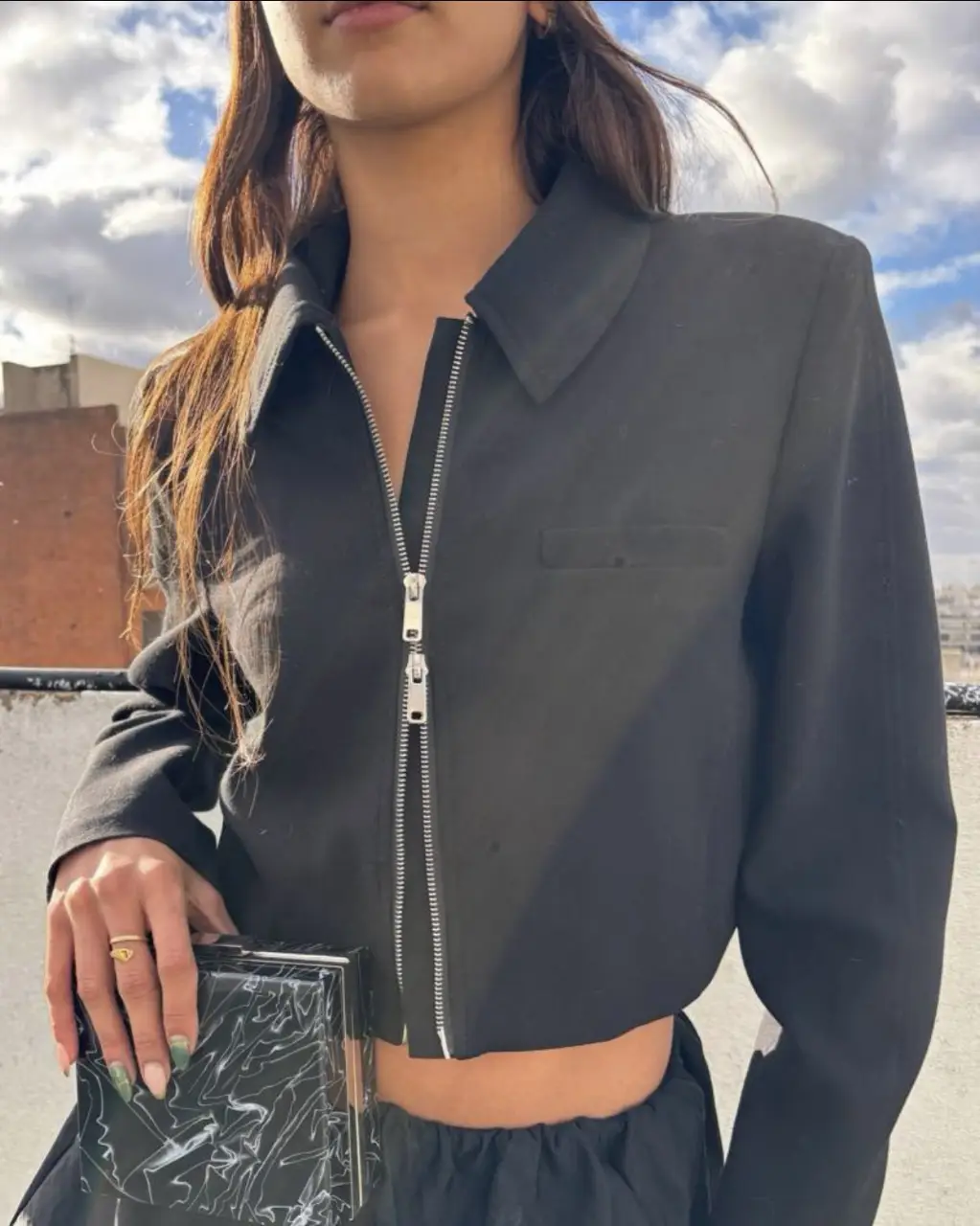 Chaqueta blazer negra de corte crop con cierre metálico. Ideal para un look moderno y sofisticado.