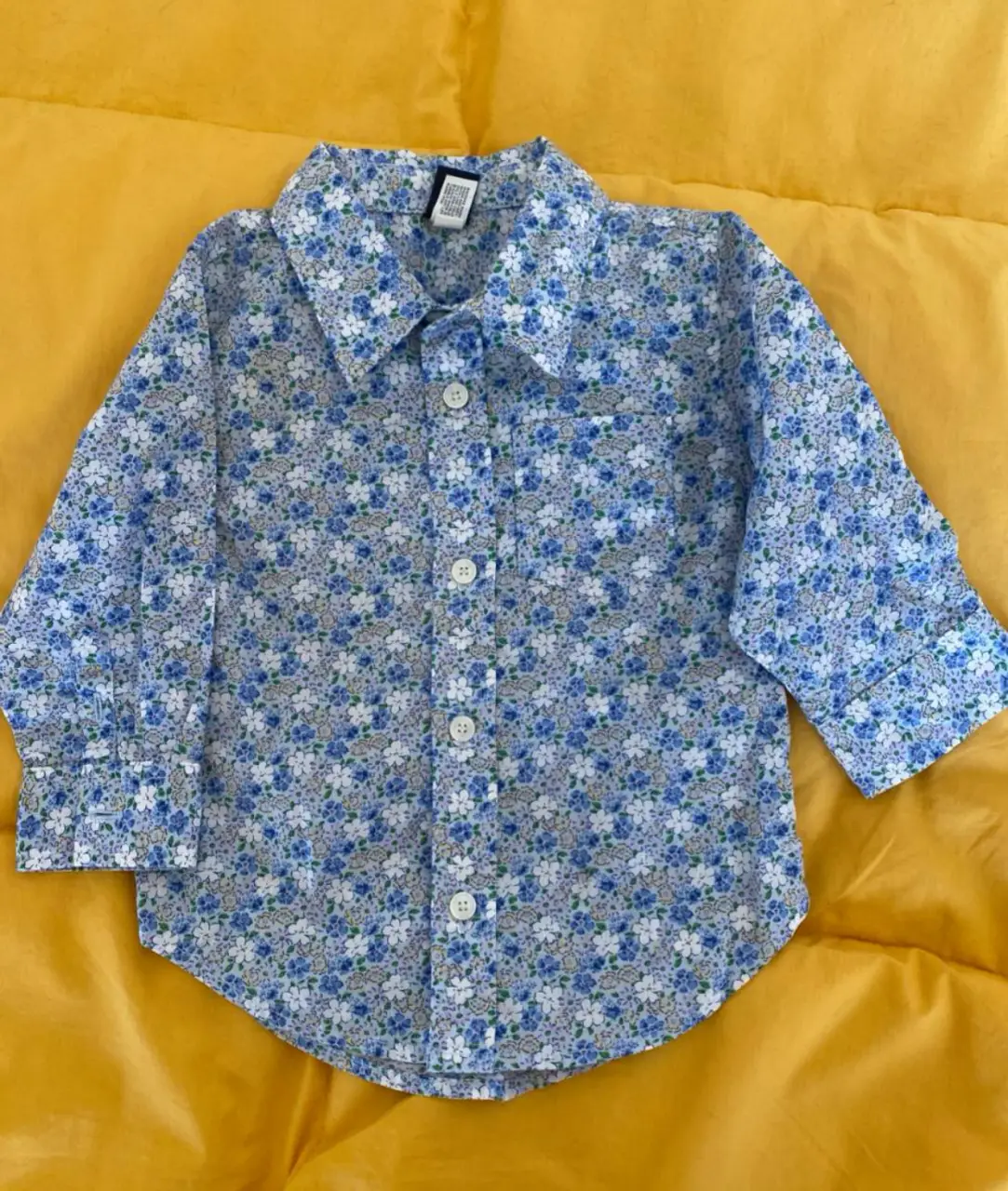 Camisa de bebé con estampado floral en tonos azules y blancos. Ideal para un look casual y cómodo. Con botones y bolsillo en el pecho. Perfecta para niños.