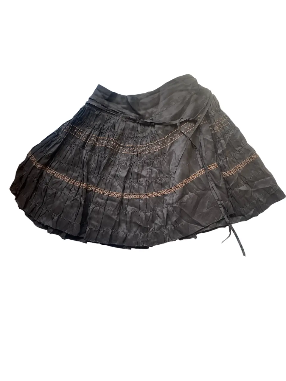 Pollera MIDI de tela negra con detalles bordados en color marrón. Diseño con volados y lazos para ajustar. Ideal para un look bohemio y casual. 100% seda