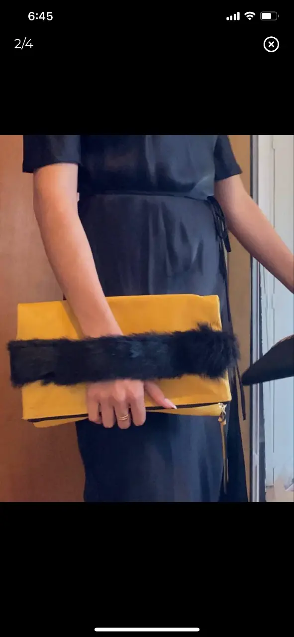 Cartera sobre de cuero amarilla plegable con detalle de piel negra. Ideal para eventos y salidas. 