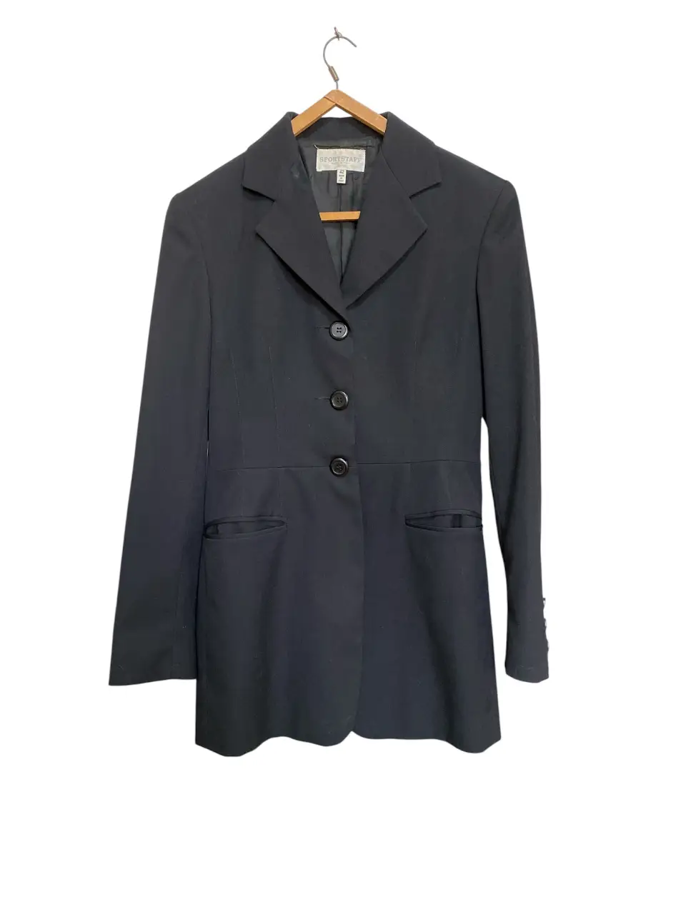 Blazer negro de mujer, corte clásico con tres botones y bolsillos delanteros. Ideal para un look formal o de trabajo. Único detalle esa manchita en la solapa