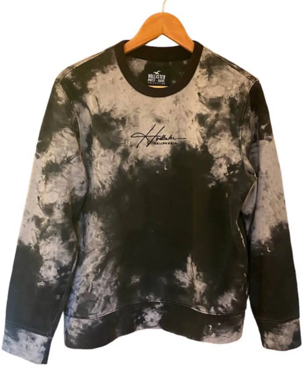 Buzo de cuello redondo Hollister para mujer, con diseño tie dye en tonos grises y negros. Talle S. Ideal para un look casual y cómodo.
