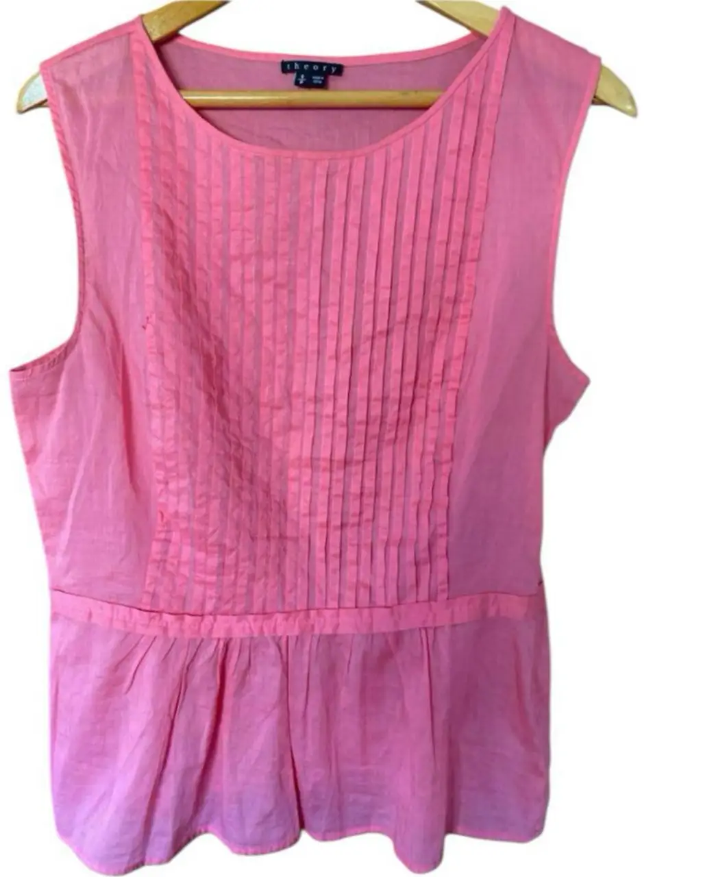 Blusa rosa de Theory, sin mangas, con detalles plisados en el frente y cintura marcada. Ideal para un look elegante y fresco. Tiene una pequeña manchita, abajo (ver foto)