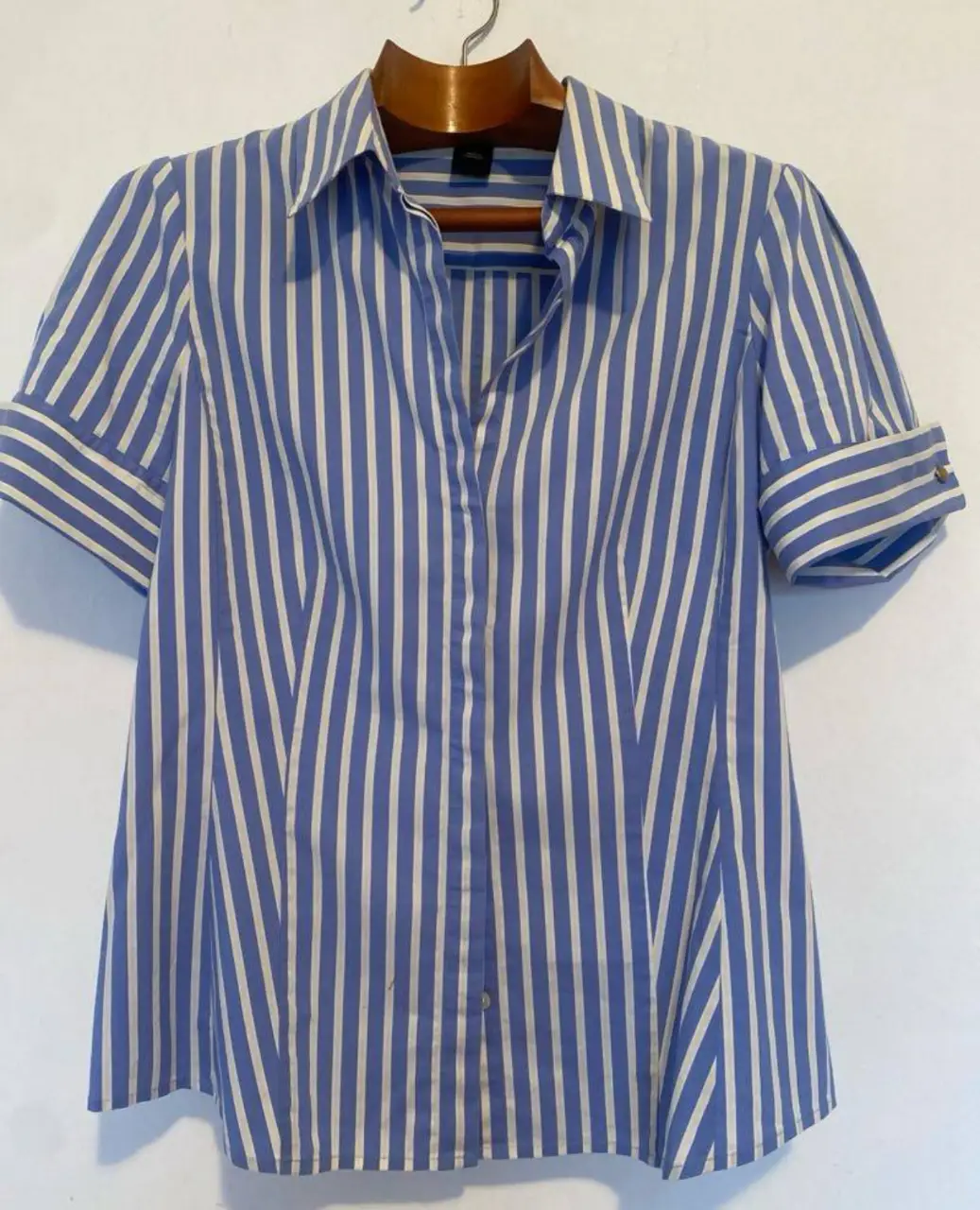 Camisa de mujer a rayas verticales en azul y blanco, con mangas cortas y detalles de botones en los puños. Ideal para un look casual o de trabajo.