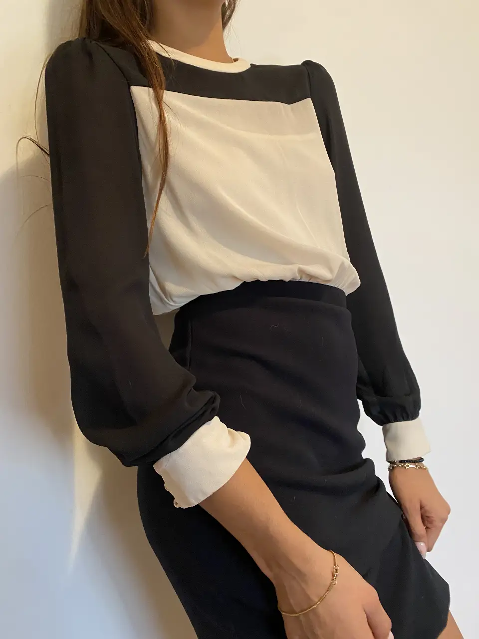 Vestido midi de dos piezas unidas, con top blanco y negro con mangas largas y falda negra. Ideal para un look elegante y sofisticado.