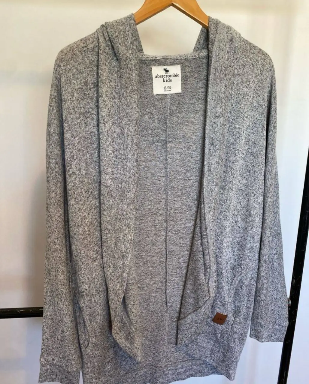 Cardigan abierto con capucha para niña, de la marca Abercrombie. Color gris jaspeado, ideal para un look casual y cómodo. va para muchísimos talles