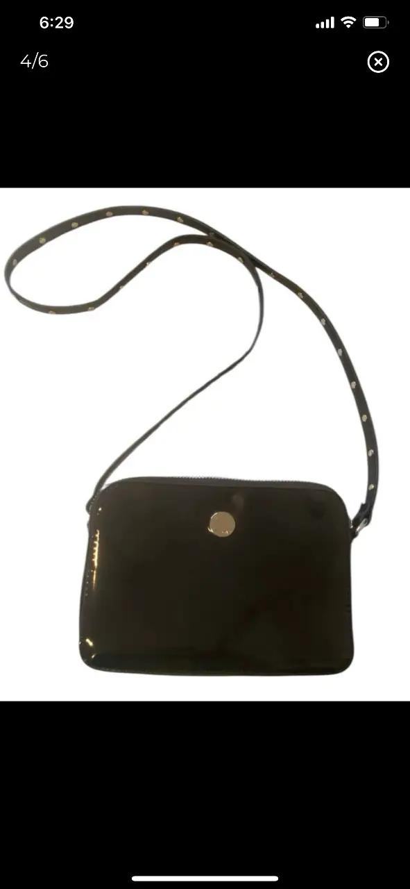 Bandolera negra de charol con correa ajustable y detalles metálicos. Ideal para llevar lo esencial con estilo. 20x15 correa 104cm 