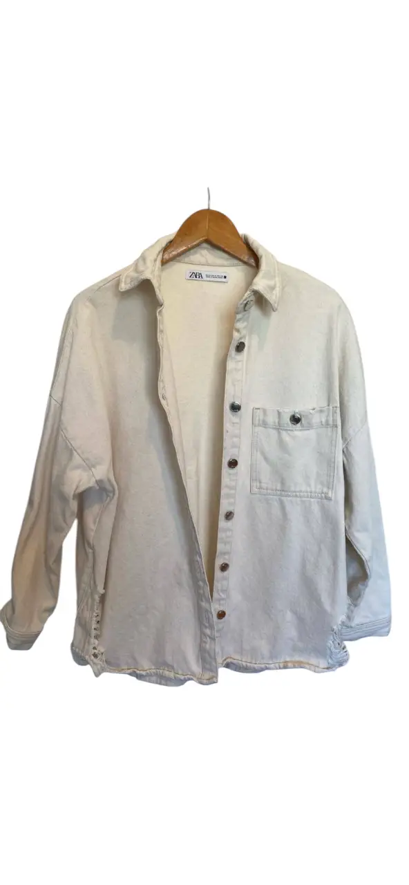 Camisa de jean Zara color crudo, con detalles de roturas en el bajo. Ideal para un look casual y canchero.